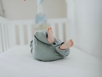 Cute baby feet in pajamas on a soft white crib. Perfect for children's room decor.