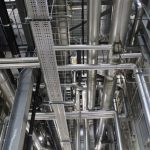 Vertical shot of steel pipes and ventilation in an industrial setting.