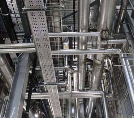 Vertical shot of steel pipes and ventilation in an industrial setting.