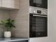 A sleek modern kitchen showcases built-in appliances with a chic plant accent on the countertop.
